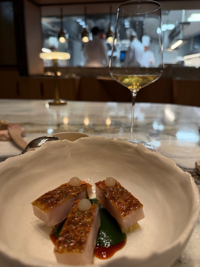 A plated course and wine at the chef’s table