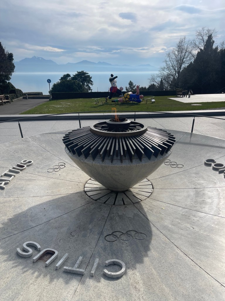 Olympic flame and rings overlooking Lake Geneva