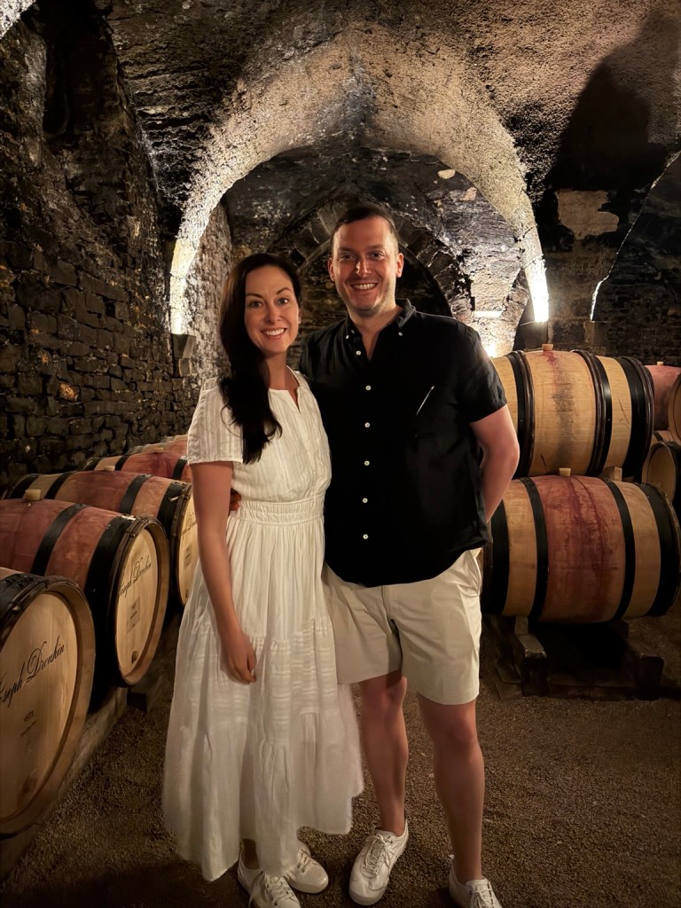 Lou and Bridget among wine barrels in the Joseph Drouhin cellar